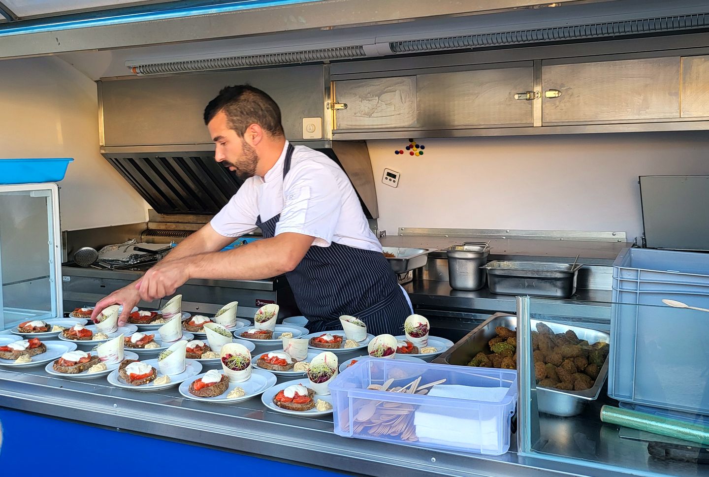 Le chef dresse des assiettes au comptoir du foodtruck