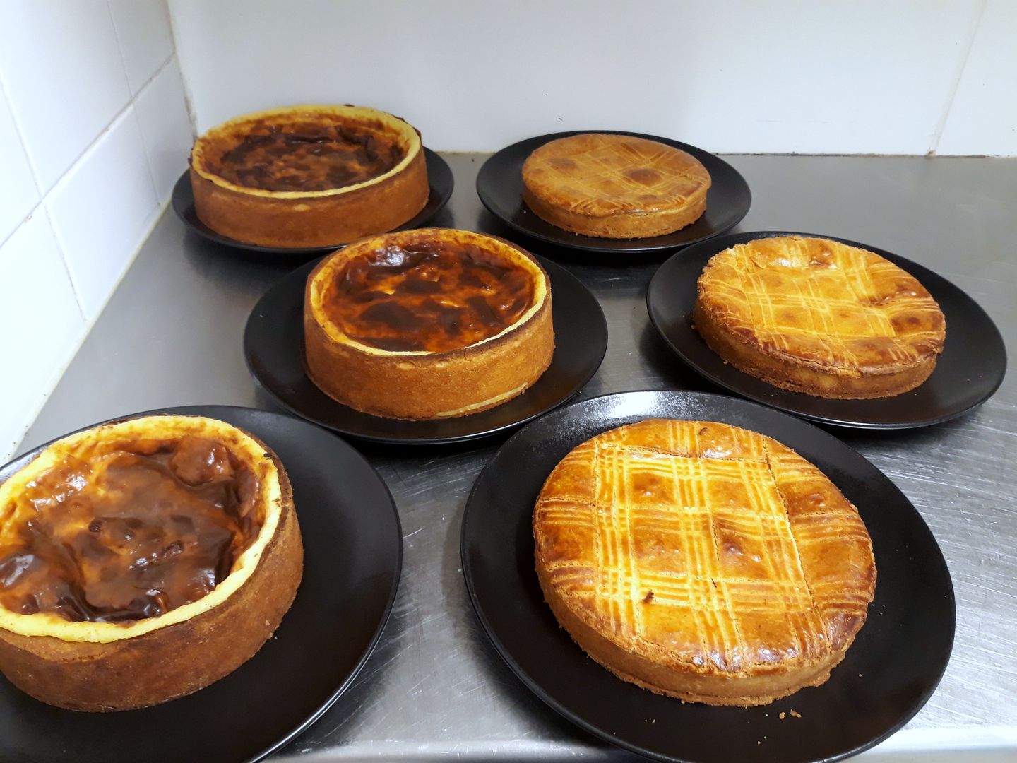 Flans pâtissiers et gâteaux basques sur assiettes noires