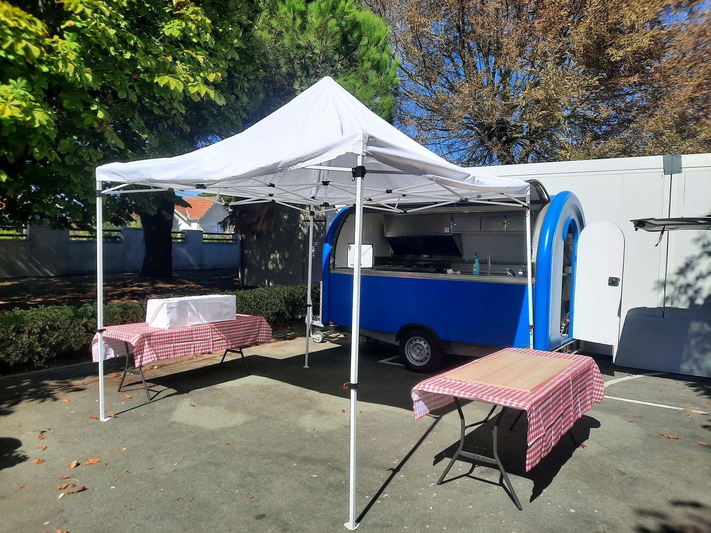Foodtruck, barnum blanc et tables en nappe vichy installés pour une réception