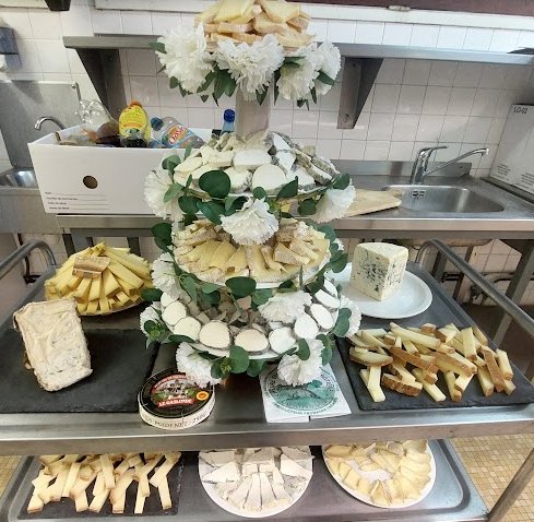 Plateau de fromages décoré de fleurs blanches