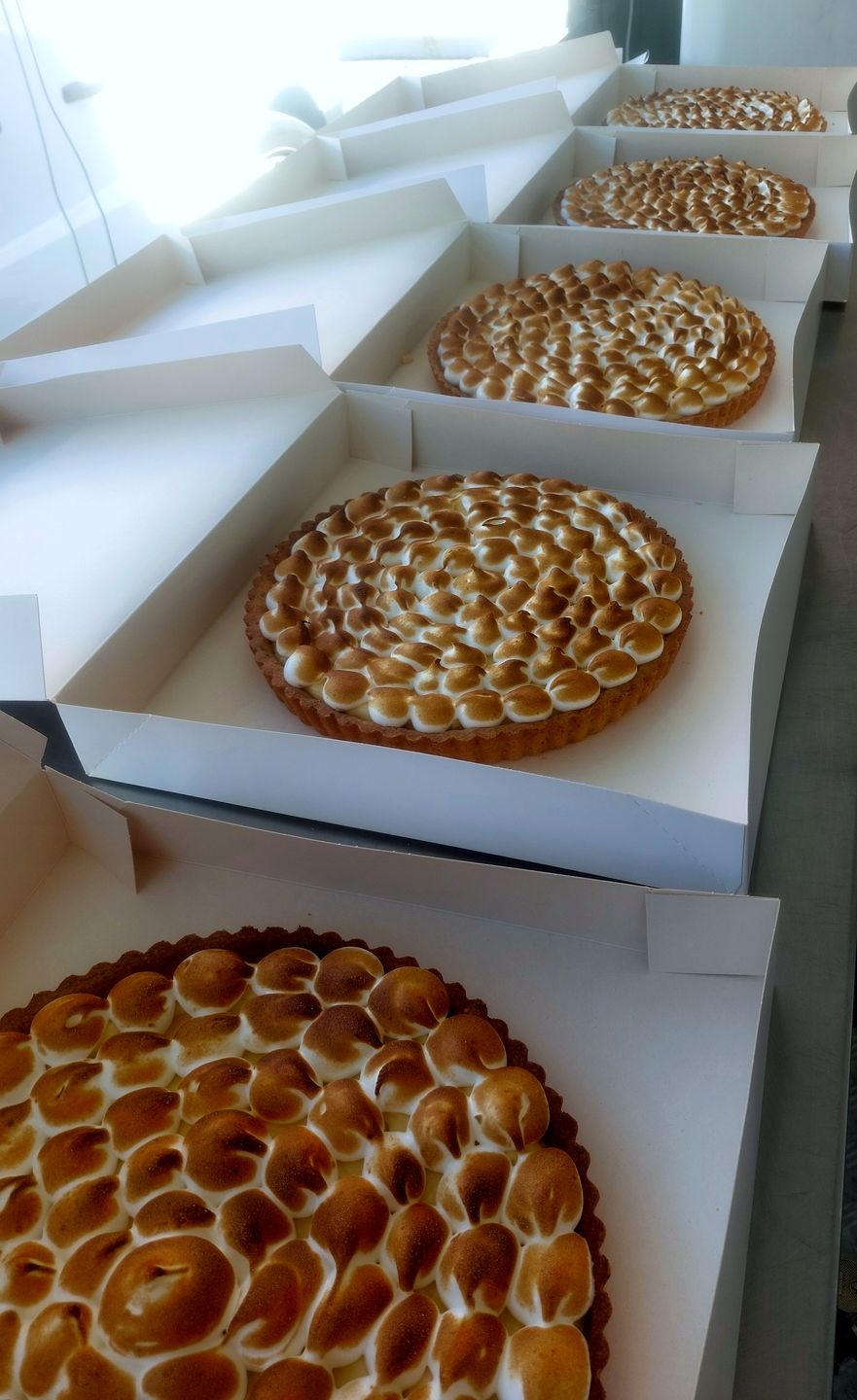 Tartes au citron meringuées alignées dans leurs boîtes